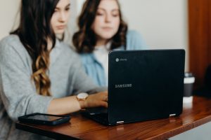 Two girls sat at a laptop